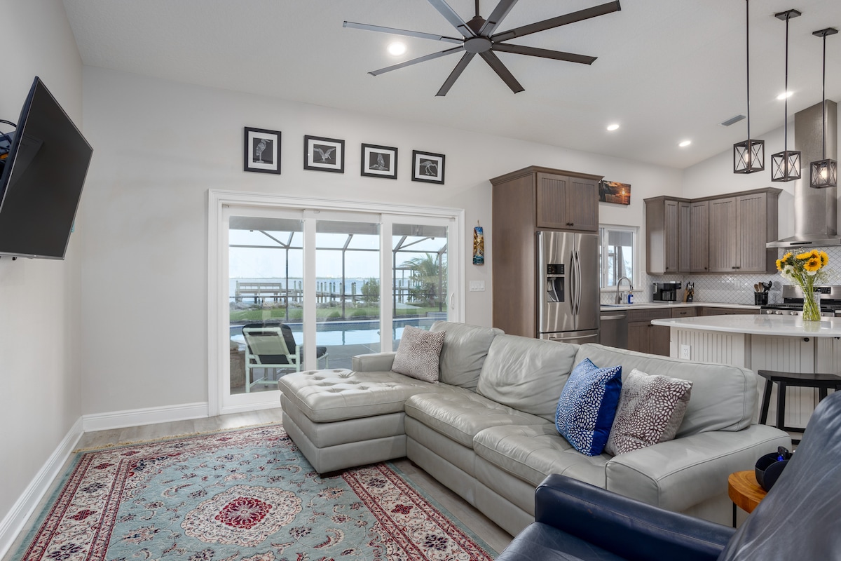 Open living room and kitchen with sliding glass doors to the pool